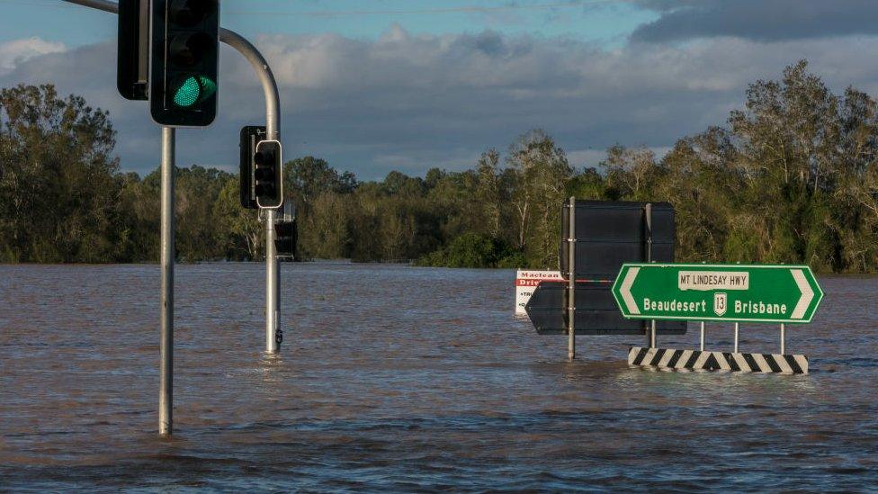 A street sign is partially submerged.