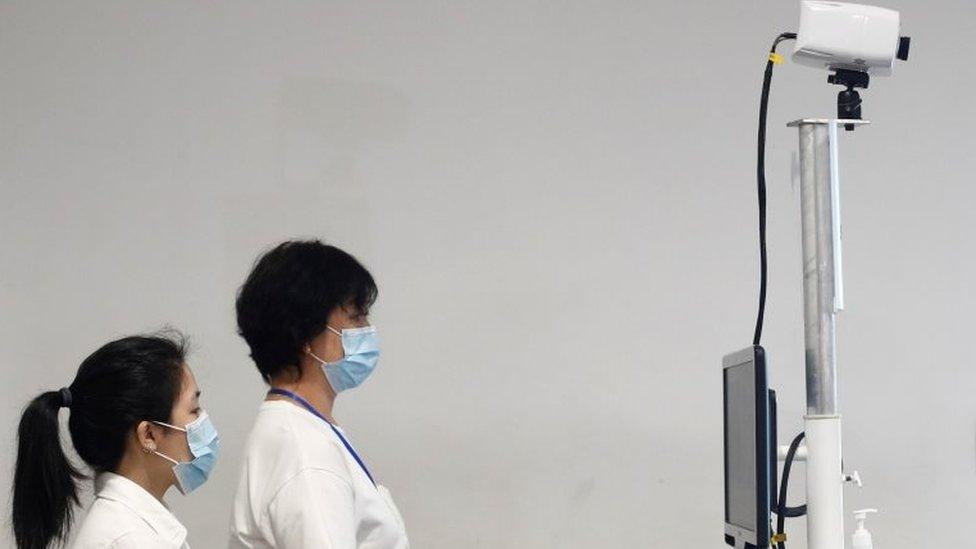 Immigration and Checkpoints Authority staff members wait for arriving passengers at a temperature screening station at the Singapore Cruise Center, following the coronavirus outbreak in Singapore