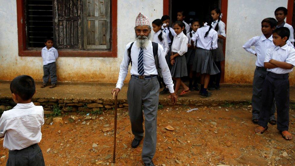 Durga Kami walks outside his school