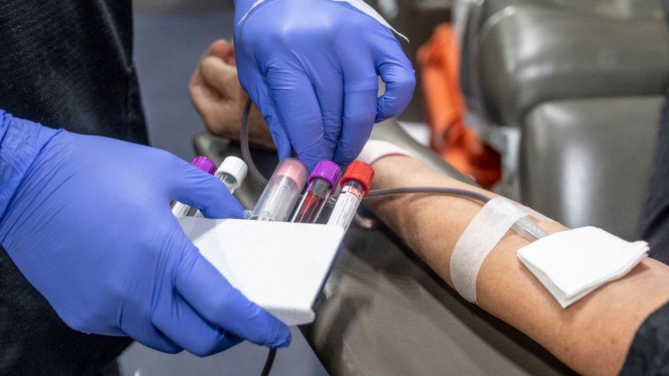 A nurse fills test tubes with blood to be tested during an American Red Cross bloodmobile in Fullerton, California