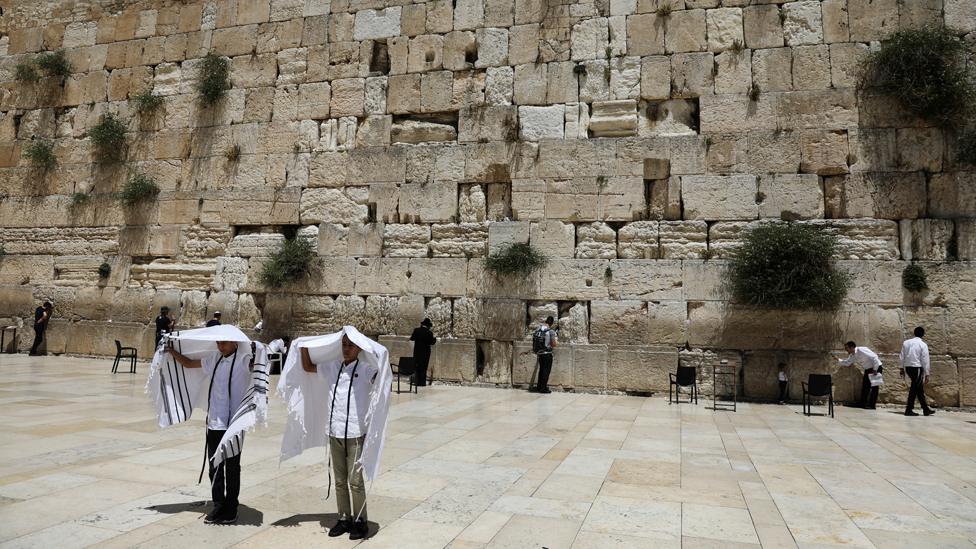 Youth hold their prayer shawls as they stand in front of the Western Wall, Judaism"s holiest prayers site in Jerusalem"s Old City May 17, 2017