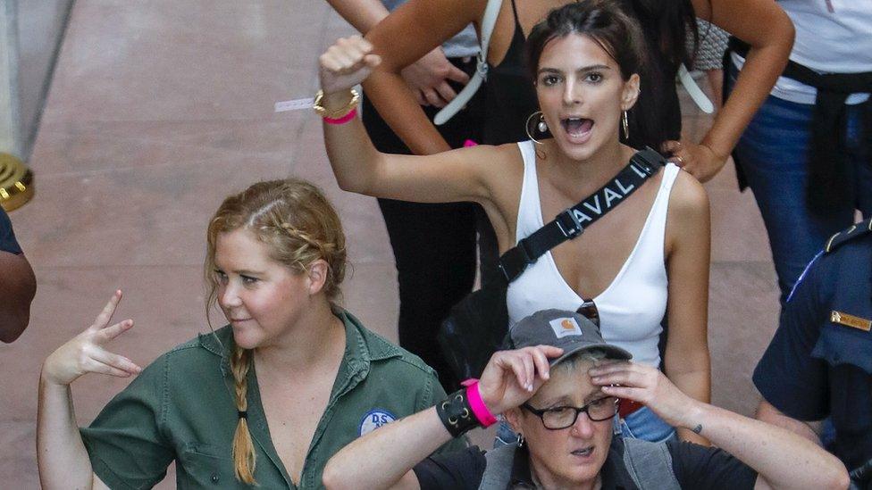 US comedian Amy Schumer (L) and US actress Emily Ratajkowski (R) gesture after getting detained along with hundreds of other protestors against the confirmation of Supreme Court nominee Judge Brett Kavanaugh at the Hart Senate Office Building in Washington DC