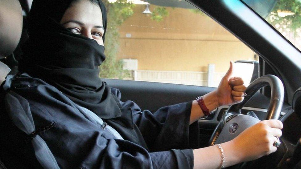 A woman gives a thumb up as she sits behind the wheel of a car in Riyadh, Saudi Arabia, 27 September 2017