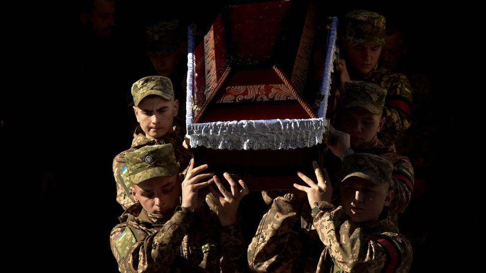 Ukrainian servicemen carry a coffin during a funeral ceremony