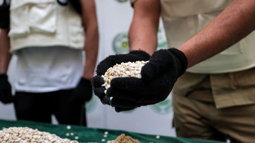 Saudi officers holding Captagon pills