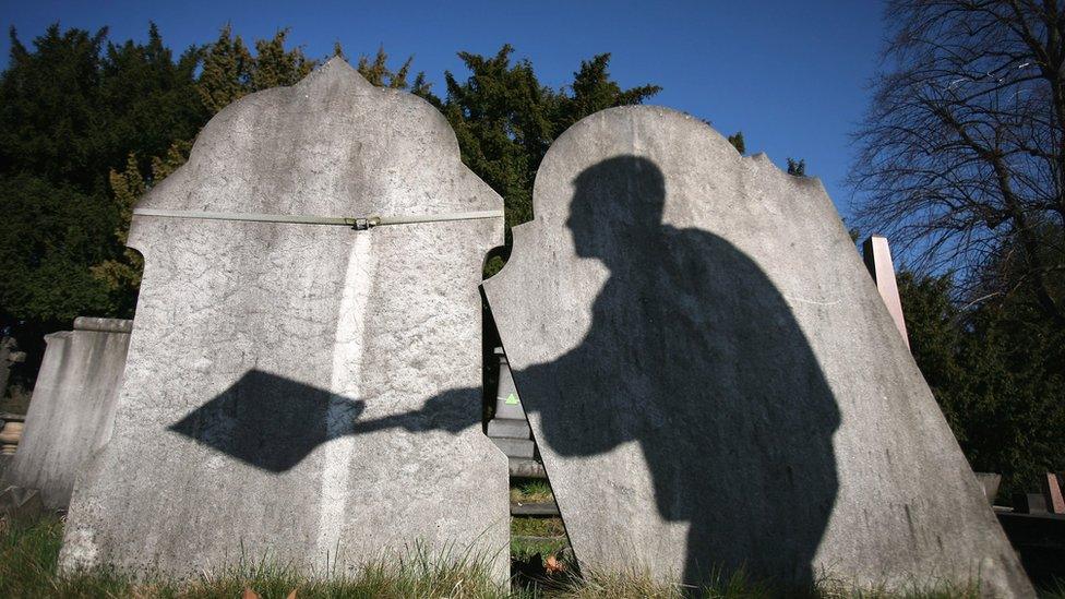 Gravestones with a shadow of a man on