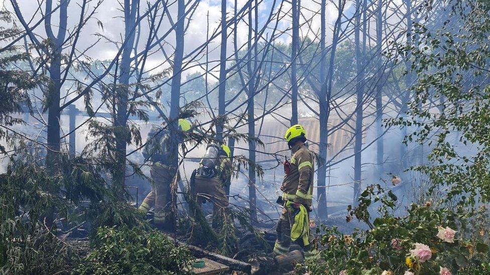 Firefighters tackling a blaze in a yard