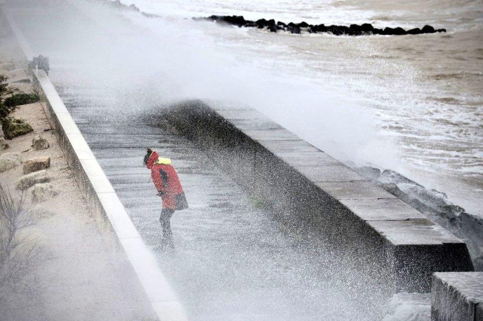 A woman is splashed by the waves on the Quai du Lazaret near the Port des Minimes in La Rochelle, centre-western France, on November 2, 2023, as the storm Ciaran hits the region.