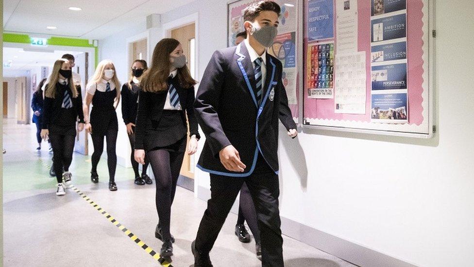 Masked pupils in school corridor