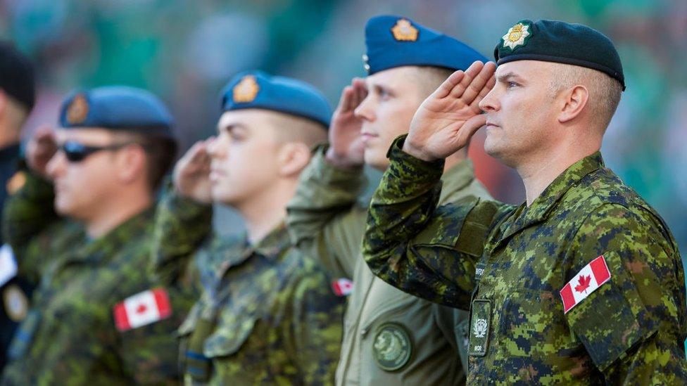 Members of the Canadian Forces salute during the national anthem before the game between the BC Lions and the Saskatchewan Roughriders at Mosaic Stadium on August 13, 2017 in Regina, Canada