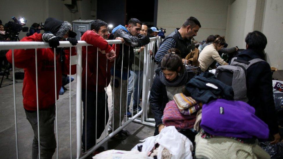 Homeless people wait to receive donations from volunteers at the River Plate stadium in Buenos Aires, Argentina