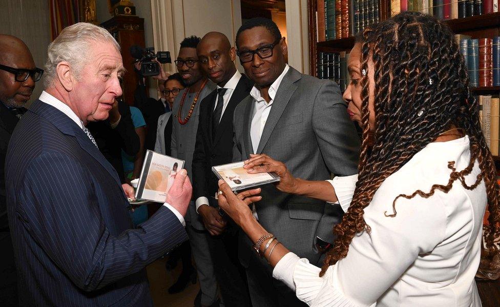 Prince Charles, Prince of Wales is presented with a CD from Composer Shirley Thompson as he hosts a reception for supporters of The Powerlist at Clarence House on March 01, 2022