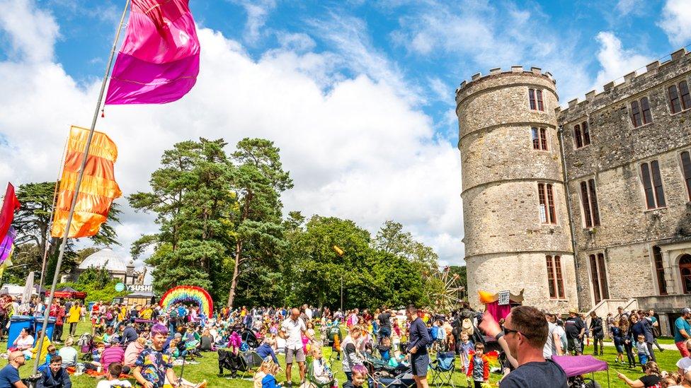 A crowd of festival-goers next to Lulworth Castle