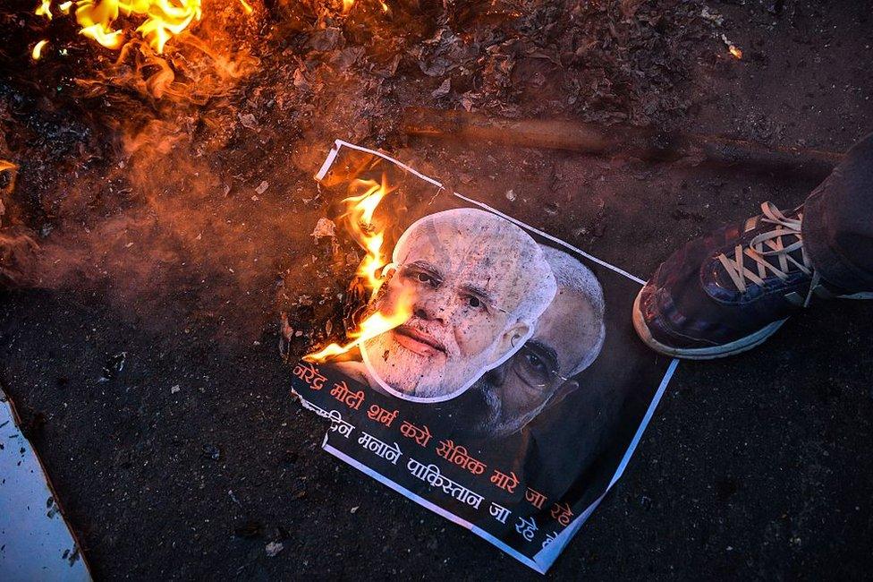 Activists of the Indian Youth Congress burn a poster with images of Indian prime minister Narindra Modi and Pakistan prime minister Nawaz Sharif during Modi's visit to Pakistan, on December 25, 2015