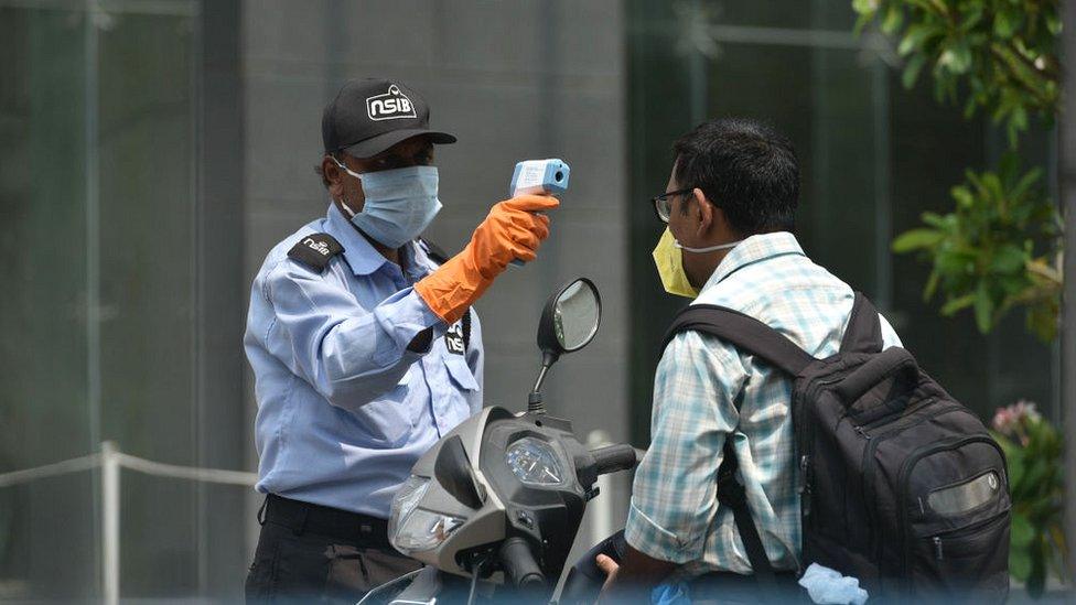 Price Waterhouse Coopers employees undergo thermal screening before entering the building on first day of partial relaxations during lockdown, at Sector V, Salt Lake, on April 20, 2020 in Kolkata, India