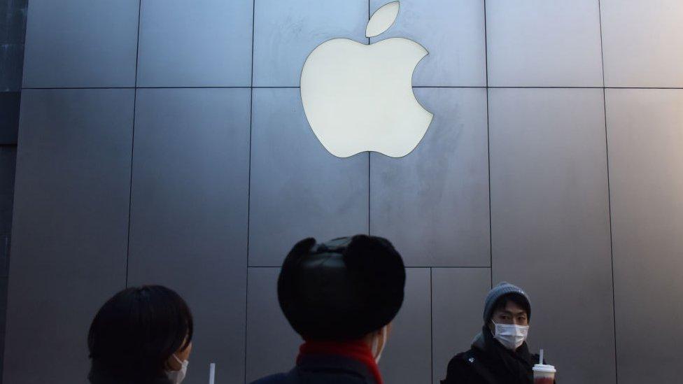 People stand in front of an Apple store in China