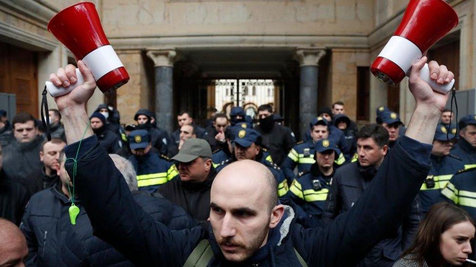 People take part in a rally in front of Parliament building in Tbilisi, Georgia