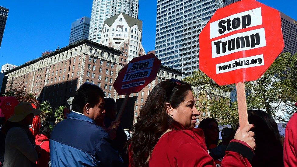 Anti-Trump protesters hold signs in Los Angeles, a sanctuary city.