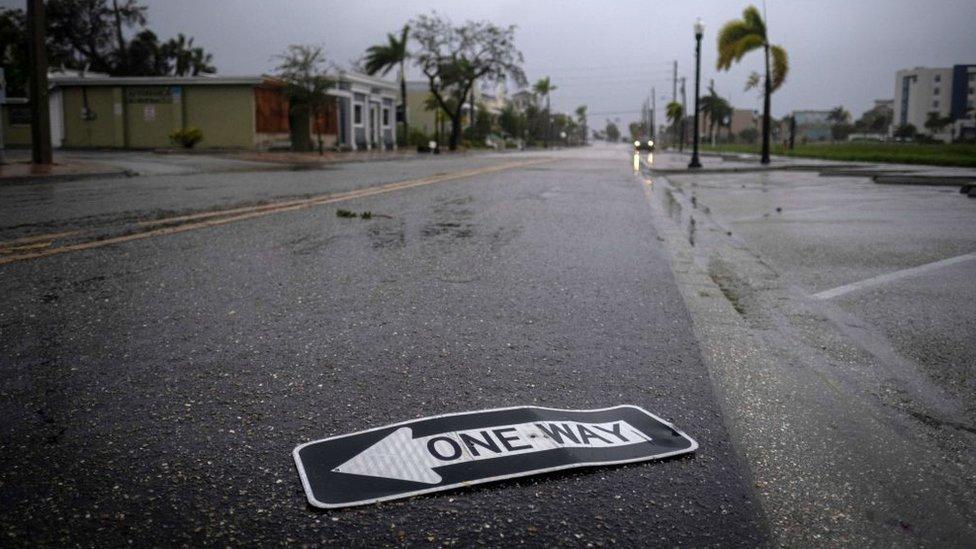 A one way sign on the ground.