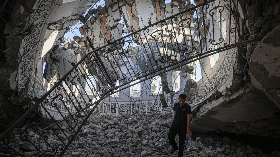 A man observes the damage to the Khalid Bin Al-Waleed mosque from inside the dome