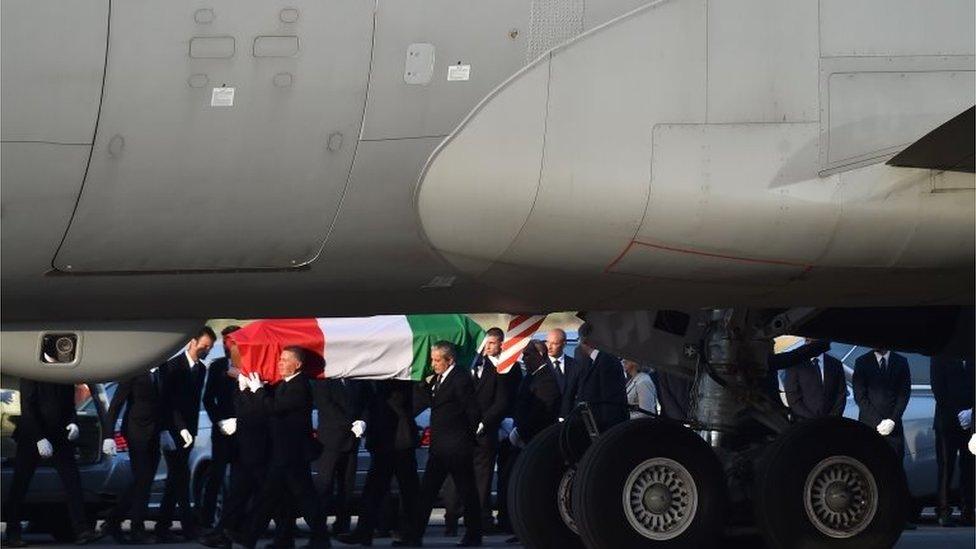 A coffin containing the body of one of the nine Italians killed in the Bangladesh attack is carried by pallbearers as it is disembarked from an Italian airplane at Ciampino military airbase, near Rome, on July 5, 2016.