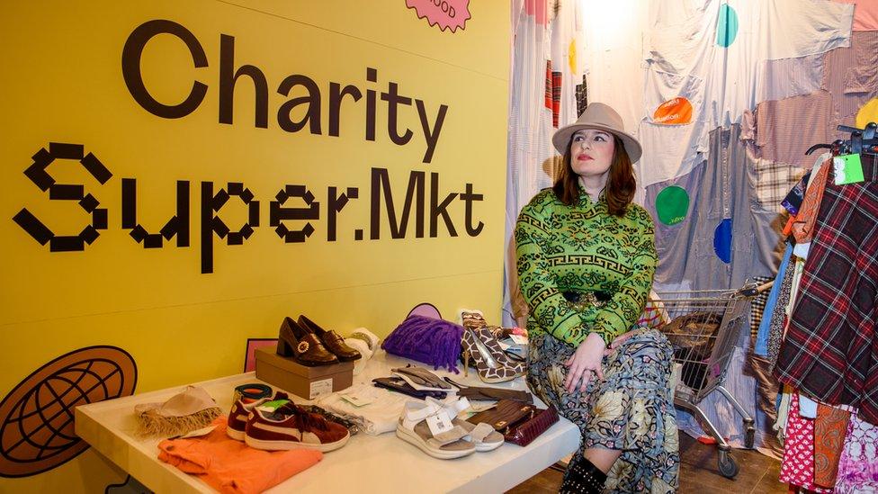 A woman sitting on a table with clothes