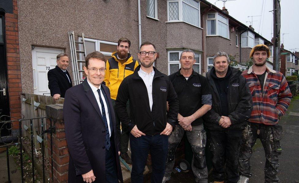 Andy Street and Gavin Mullaley with some tradespeople who have helped refurbish properties in Coventry