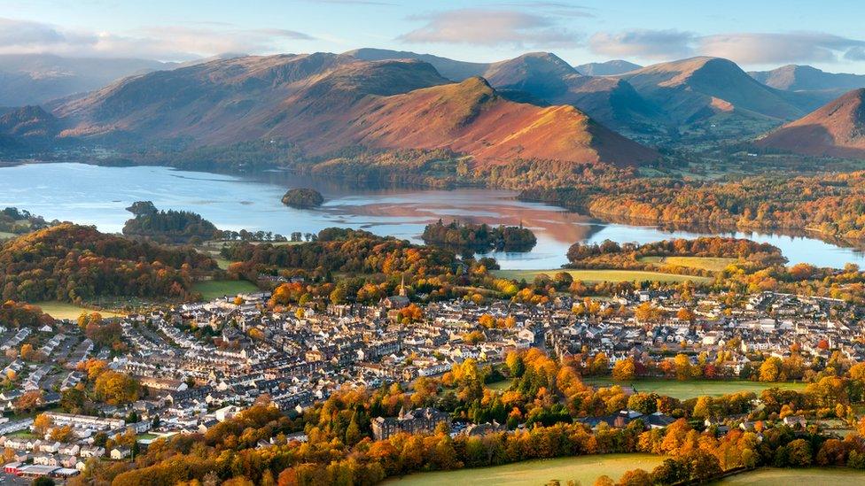 Aerial view of Keswick next to lake and mountains