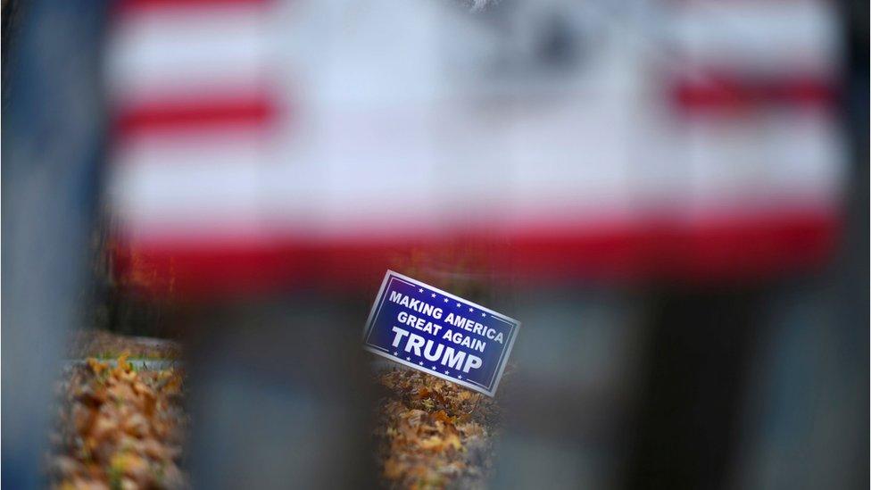 A blue yard sign with white lettering.