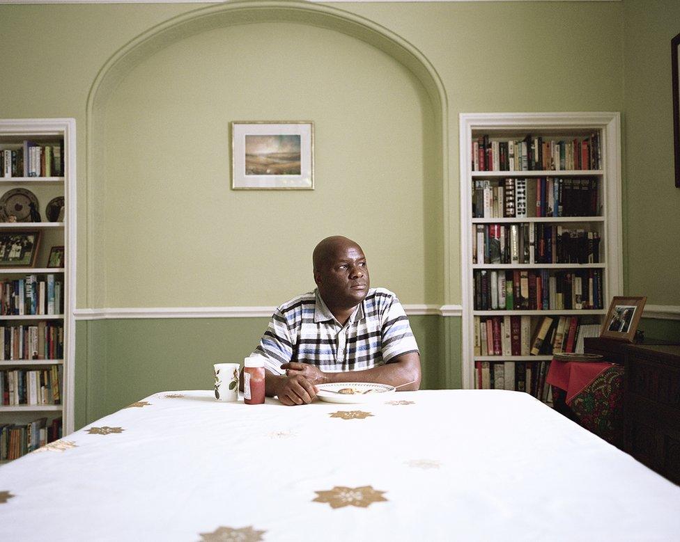 A man sits at the end of a table.