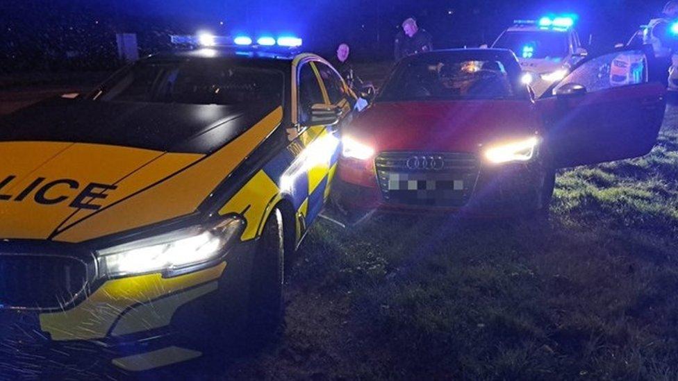 Police cars and a red Audi after a police chase in Swindon