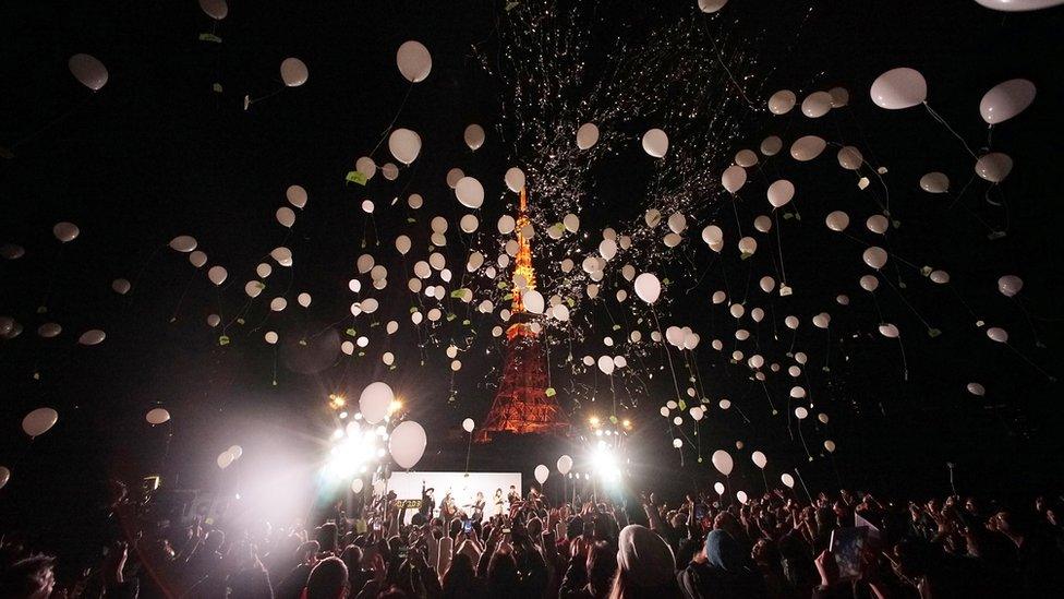 People release balloons to celebrate the New Year with Tokyo Tower in the background in Tokyo