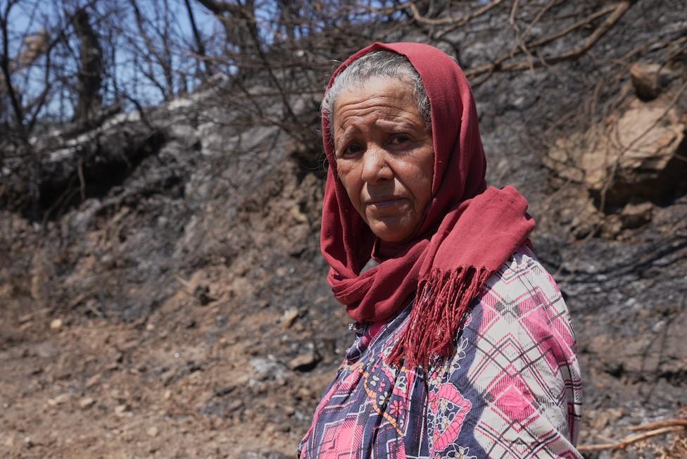 Mounia Hamiss standing near burned trees