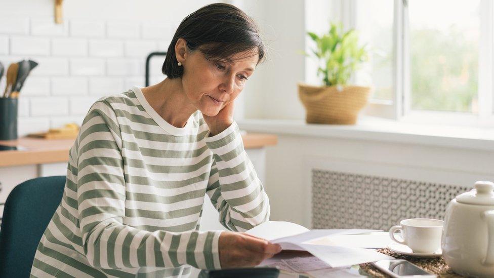 A woman looking at a high bill