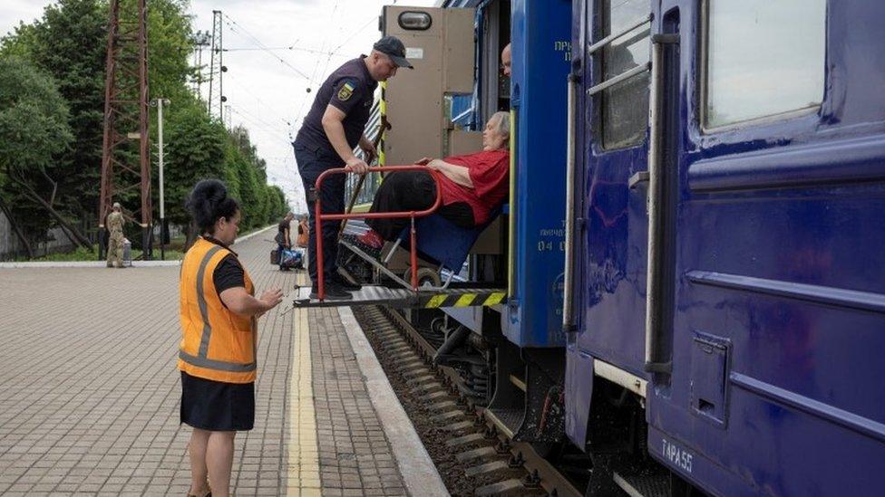 Ukrainian police officers help Elena from Lysychansk to board a train to Dnipro and Lviv during an evacuation of civilians from war-affected areas of eastern Ukraine, amid Russia"s invasion of the country, in Pokrovsk, Donetsk region, Ukraine, June 25, 2022.