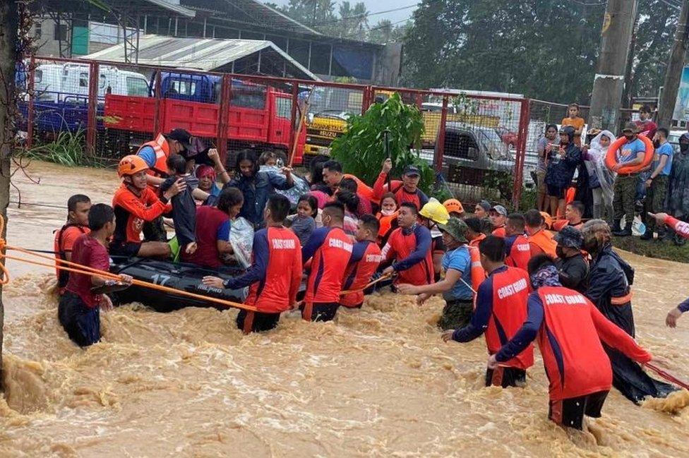 Philippine Coast Guard personnel rescue stranded residents from floods in Cagayan De Oro City, Philippines. Photo: 16 December 2021