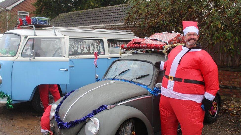 Man dressed as santa next to vw car