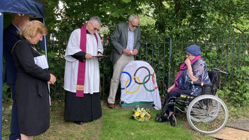 ceremony at a gravestone unveiling, with Vanessa in a wheelchair