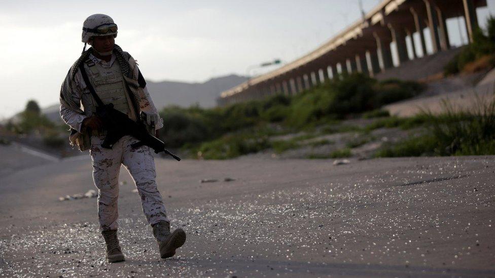 A member of the Mexican National Guard patrols on the banks of the Rio Bravo river at the border between Mexico and the US as seen from Ciudad Juarez