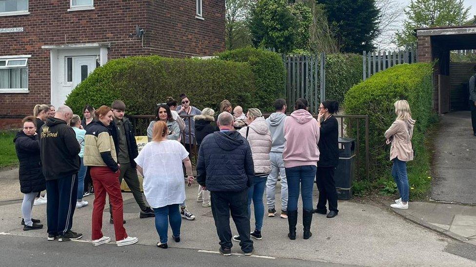 Parents waiting outside a side entrance to Birley Academy in Sheffield