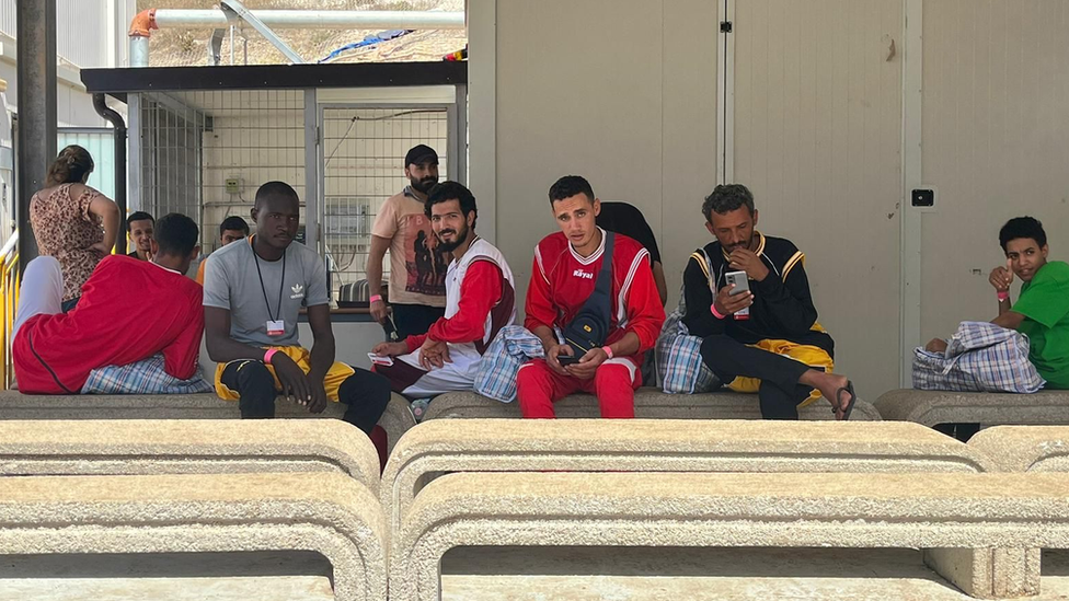 People sitting outside the Hotspot migrant centre