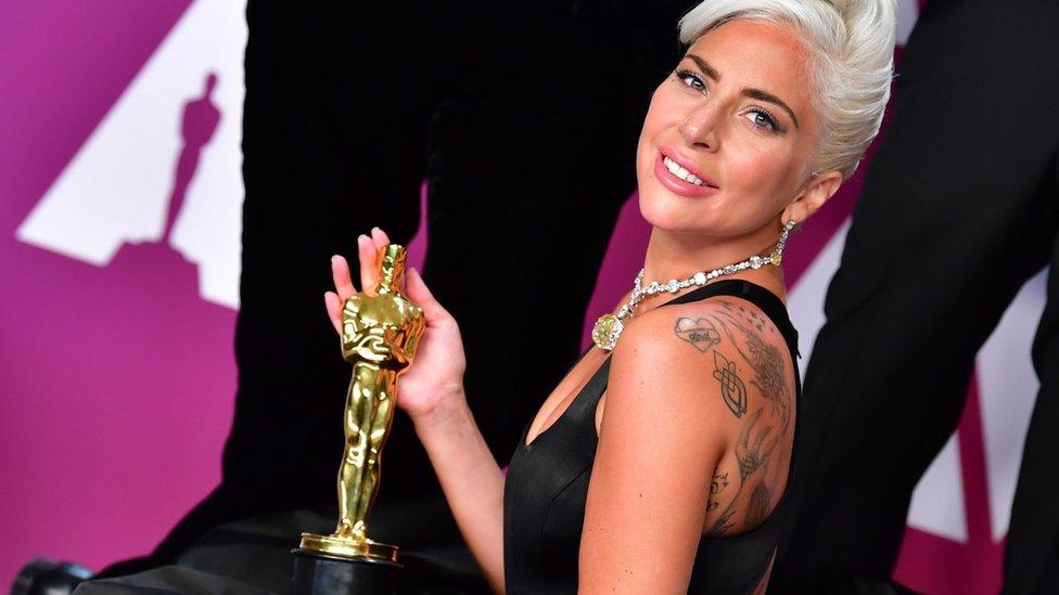 Lady Gaga holding her award