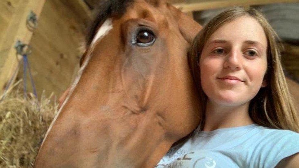 Brodie takes a selfie next to a horse