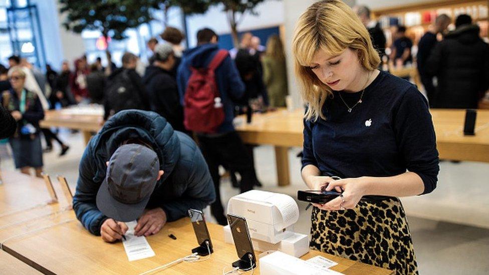 A customer checking an iPhone at store