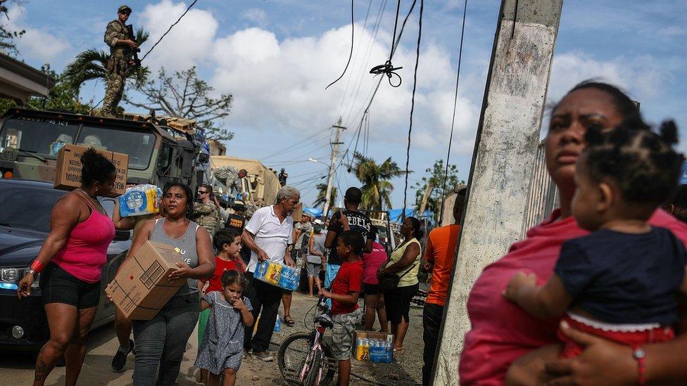 Residents gather and receive food and water provided by Fema in San Isidro, Puerto Rico