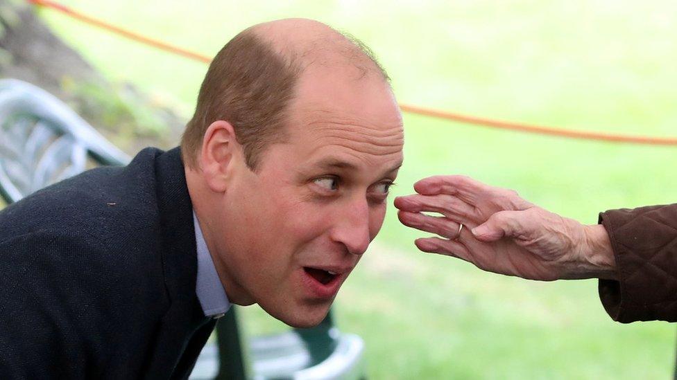 Resident Betty Magee, 96, reaches out to touch Prince William's face at the Queen's Bay Lodge Care Home