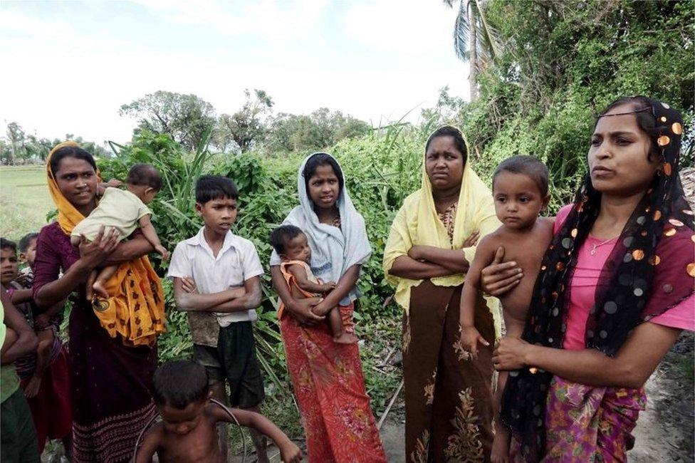 This photo taken on 15 July 2017 shows Ayamar Bagon (L), 20, Hasamithaya (C), 18, Laila Baygon (3rd R), 35, and Hasinnar Baygon (R), 20, who claim they were raped by soldiers during a clearance operation last year, holding their children as they speak to reporters near a field in Kyar Gaung Taung village in Maungdaw.