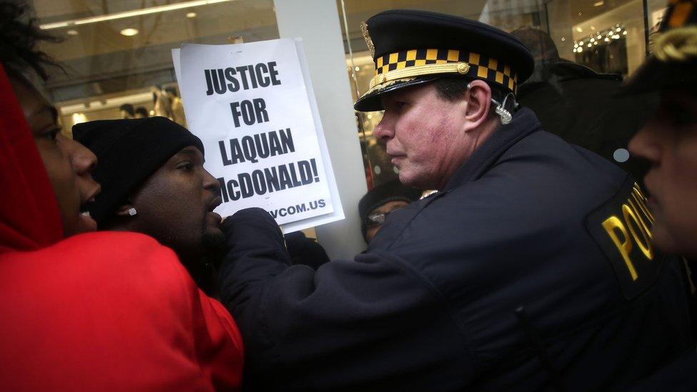 Police officers push back demonstrators who continue to protest the fatal police shooting of Laquan McDonald as they attempt to disrupt holiday shoppers along Michigan Avenue December 24, 2015 in Chicago, Illinois.