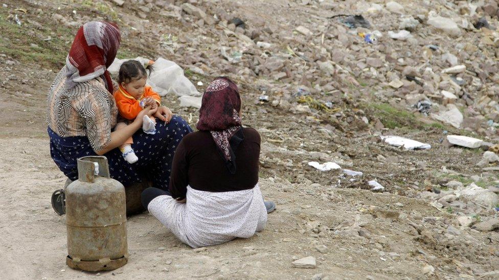 Iranian women rest in a poor neighbourhood