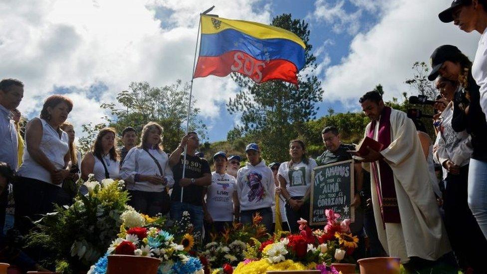 Former elite police officer Oscar Perez"s relatives and friends attend a mass next to his gravesite at a cemetery in Caracas on January 21, 2018.